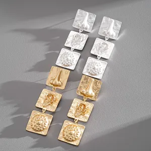 Detailed close-up of exaggerated geometric earrings with unique anatomical motifs.