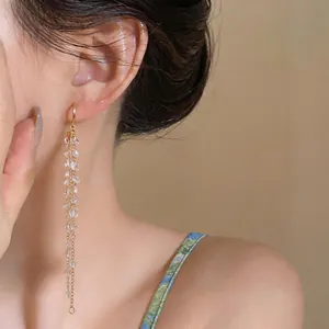 Elegant long tassel earrings featuring sparkling clear bead clusters on gold chains