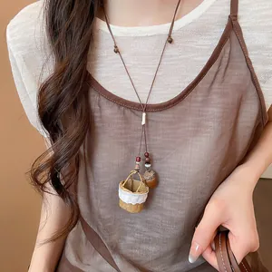 Close-up detail of a New Chinese style necklace featuring mini basket and acorn pendants