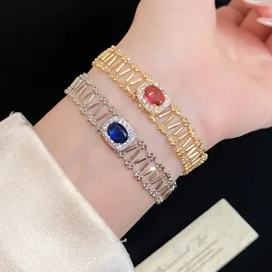 Elegant vintage hollow bracelets with red and blue zircon gemstones displayed on a wrist.