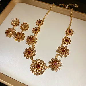 Detailed view of retro palace style necklace and earrings set with amber rhinestones.