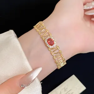 Detailed close-up of a vintage gold-toned bracelet with a red oval zirconia center.