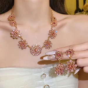 Vintage palace style jewelry set with pink rhinestones on gold circular hollow pendants.