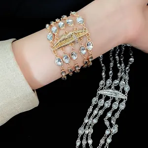 Elegante bracciale multistrato in strass dorati con ciondolo a labbra testurizzate