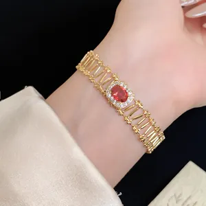 Vintage style gold bracelet with oval red zircon and elegant hollow links on a model wrist