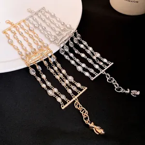 Bracciale multistrato con strass e ciondolo a forma di labbra in tonalità oro e argento