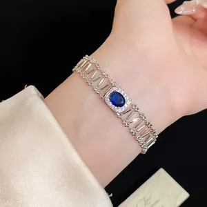 Close-up detail of a vintage zircon bracelet with an oval blue gemstone on wrist.