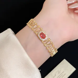 Detailed view of a vintage gold hollow bracelet with an oval red zircon center
