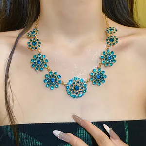 Detailed view of a vintage palace style necklace with blue rhinestone flowers.