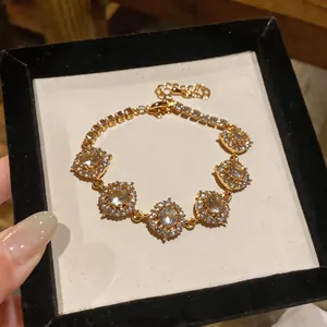 Primo piano di un elegante bracciale placcato oro 18 carati con pietre di zircone lucide