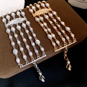 Primo piano di un bracciale multistrato con strass ed elemento labbra in oro e argento