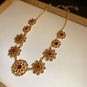 Close-up of vintage palace style necklace with amber rhinestones and hollow floral motifs