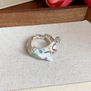 Vue macro détaillée de la bague fleur en émail bleu clair avec finition argentée martelée.