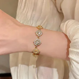 Dettaglio di un bracciale tondo in zircone placcato oro 18 carati su un polso umano.