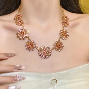 Close-up view of a retro palace style floral necklace with pink rhinestones on a model