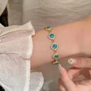 Primo piano di un braccialetto placcato oro 18 carats con zirconi blu sul polso