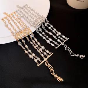 Primo piano dettagliato di braccialetti multistrato con strass e ciondolo a forma di labbra