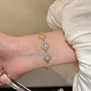 Primo piano dettagliato di un elegante bracciale placcato oro 18K con ciondoli in zircone.