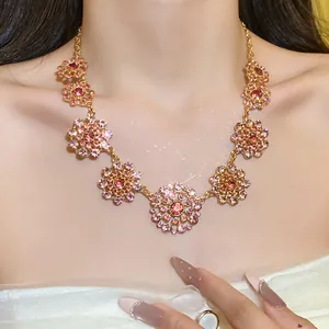 Detailed view of a vintage palace style gold necklace with pink crystal flower charms