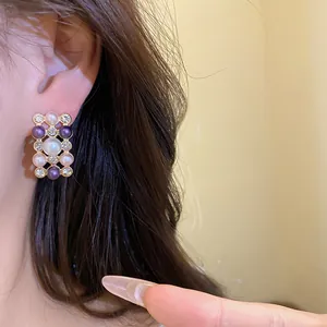 Gros plan de boucles d'oreilles rétro avec perles et perles violettes sur le modèle