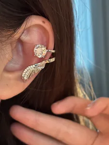 Makroansicht einer eleganten silbernen Ohrmanschette mit funkelndem Zirkonia im Engelsflügel-Design