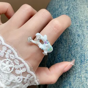 Vue rapprochée d'une bague fleur en émail blanc avec détails en cristaux brillants portée