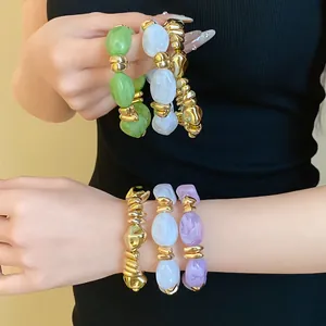 Detalle de pulseras elásticas vintage de acrílico con diseño geométrico irregular.