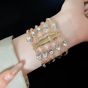 Vista dettagliata di un elegante bracciale dorato multistrato con cristalli ovali e labbra.