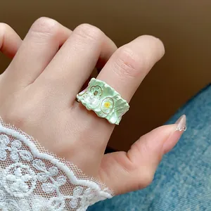 Vue macro détaillée d'une bague fleur en émail vert clair avec une texture unique