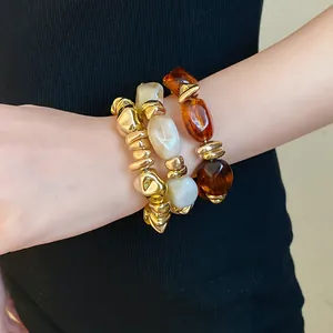 Vista detallada de pulseras elásticas de acrílico geométricas retro en tonos oro y ámbar