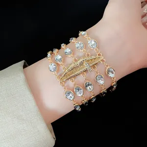 Dettaglio di un bracciale dorato multistrato con cristalli ovali e centro a labbra