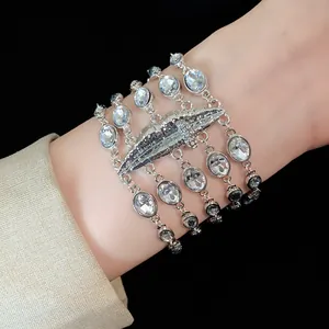 Dettaglio di un bracciale multistrato con strass e un elegante elemento centrale a labbra.