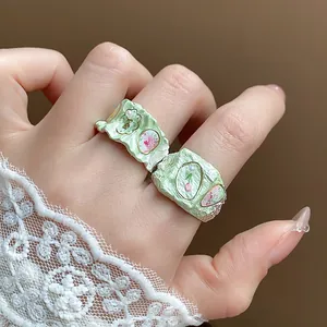 Vue détaillée de bagues en émail vert menthe avec motifs floraux et petits détails en perles