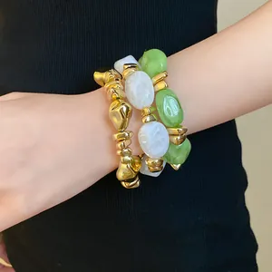 Primer plano de pulseras elásticas vintage de acrílico geométrico en tonos oro y verde