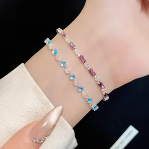 Primo piano dettagliato di eleganti braccialetti con zirconi viola e blu sul polso