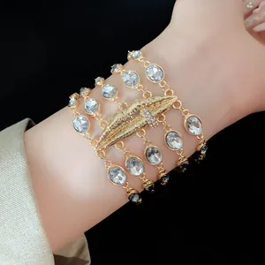 Dettaglio ravvicinato di un elegante bracciale dorato multistrato con cristalli e labbra