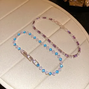Primo piano di eleganti braccialetti in zirconia viola e blu su un vassoio per gioielli