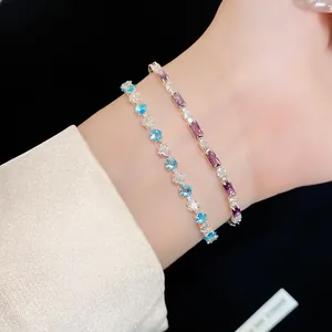 Primo piano dettagliato di eleganti braccialetti con zirconi rettangolari viola e cuori blu
