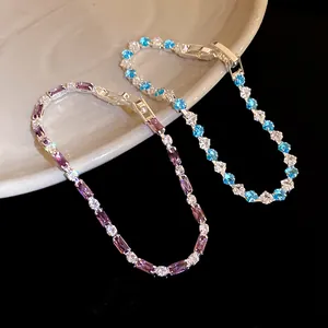 Dettaglio di eleganti bracciali in zircone viola e blu con tagli rettangolari lucidi