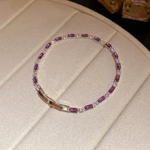 Primo piano di un elegante bracciale in zircone viola rettangolare in un portagioie beige