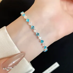Primo piano di un elegante bracciale in argento con zirconi blu e bianchi a forma di stella.