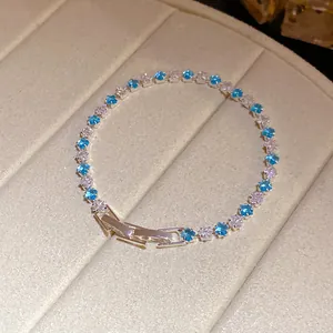 Dettaglio di un elegante braccialetto tennis con zirconi quadrati blu e bianchi