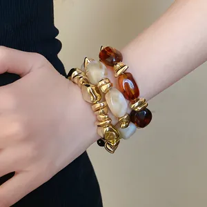 Primer plano de pulseras elásticas de acrílico vintage geométricas en la muñeca.
