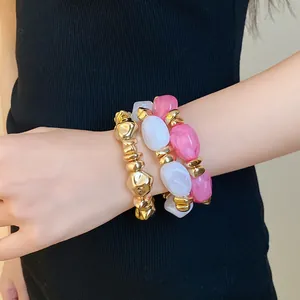 Primer plano de un conjunto de pulseras elásticas de acrílico vintage en la muñeca
