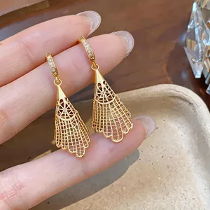 Detailed view of gold hollow lace mesh drop earrings with sparkling zircons.