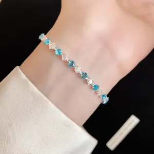 Dettaglio di un elegante bracciale con zirconi rettangolari blu e trasparenti
