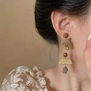 Detail view of retro handmade forest style earring on model