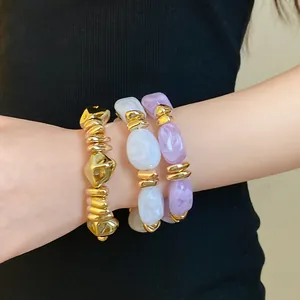 Primer plano de pulseras elásticas de acrílico geométricas con detalles dorados