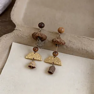 Detailed view of handmade vintage earrings featuring natural plant fruits and maple leaf charm.