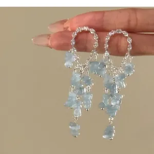 Elegant circular crystal stud earrings with dangling light blue stone tassels details